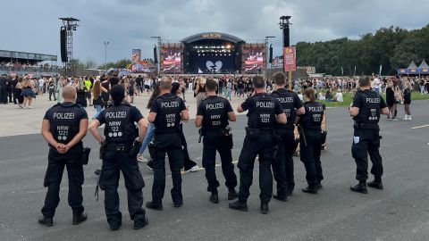 several uniformed police officers watch the goings-on from the background in front of the festival stage